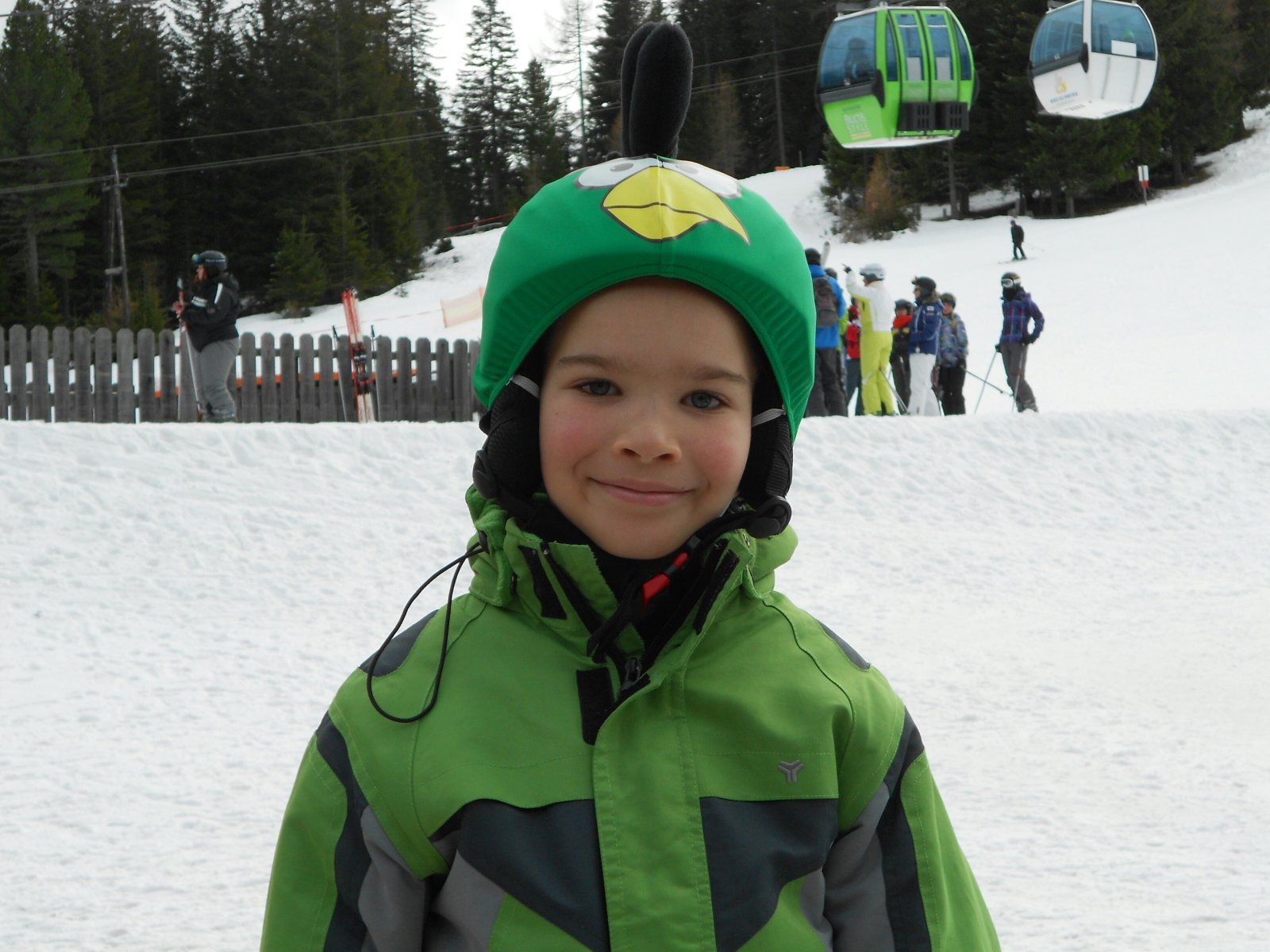 Szerb kisfiú zöld madaras sisakhuzatban