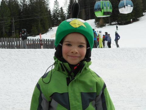 Szerb kisfiú zöld madaras sisakhuzatban