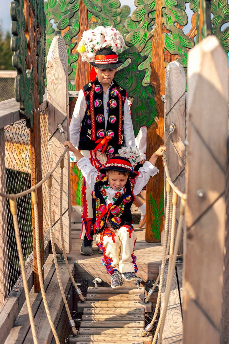 Népviseletbe öltözött gyerekek élvezik a kilátót.