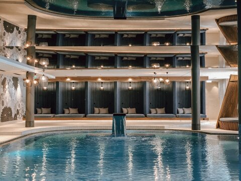 A beltéri medence látványát megduplázza a fölötte lévő hatalmas tükör, háttérben a családi pihenőkuckók | Fotó: Das Edelweiss Salzburg Mountain Resort, Lillytime