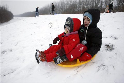 Szolnok, 2014. január 26. Gyerekek csúsznak a havon Szolnokon, egy ártéri gátoldalon 2014. január 25-én. MTI Fotó: Bugány János