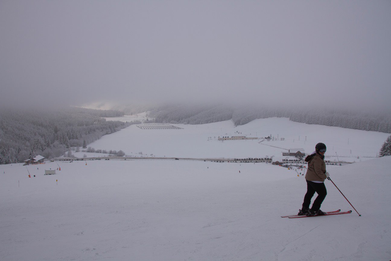 Kilátás a kispálya tetejéről. A parkoló az egyetlen hüttével, távolabb a kastély és a napelemtelep. errefelé nem megadóztatják hanem támogatják az ilyen irányú fejlesztéseket.