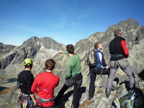 Előtérben csapatunk tagjai, az outdoor sportokhoz tervezett Icebreaker fölsőkbe öltözve, háttérben a Magas-Tátra sziklás hegyormai