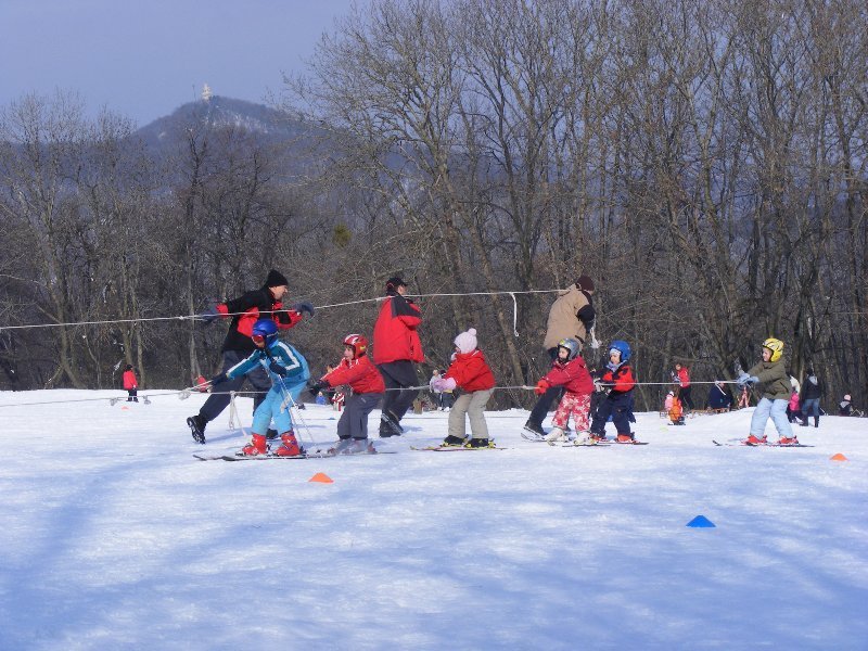 A Normafa lejtőin gyakorló síiskolában az apukák töltik be a "felvonó" szerepét.