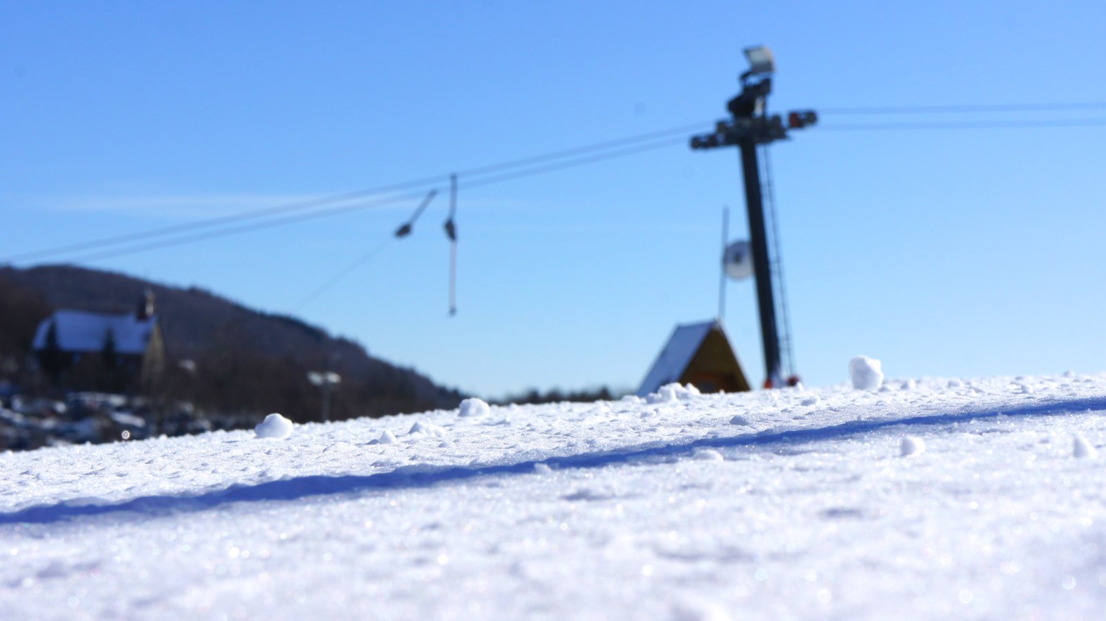 Hógolyó-özön. Kilátás a piros 3-as jelzésű sípályáról, előttünk a C jelzésű csákányos lift, és a három falu temploma.