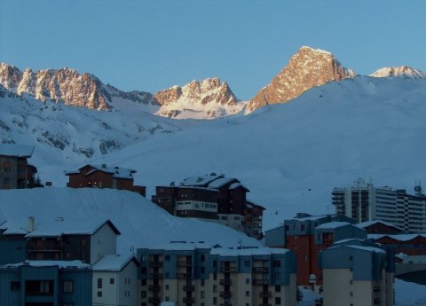 Napsugár reggeli fényei a szemben lévő csúcsokon, a város felett
