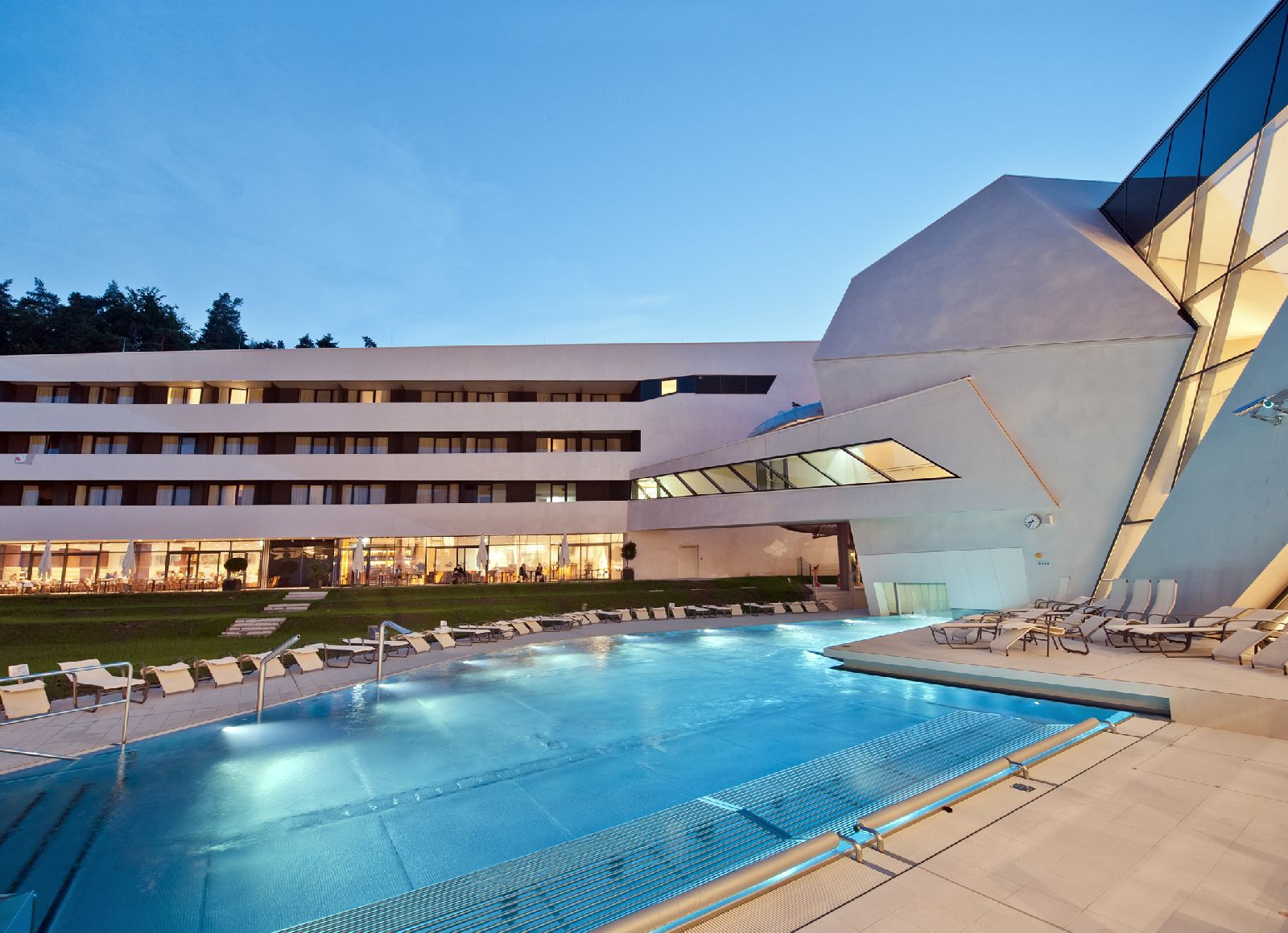 Háttérben a vadonatúj Karawankenhof Hotel szobái. A szálloda egybeépült a termálfürdővel, a szállóvendégek még a fürdő nyitása előtt élvezhetik a pancsolást és a szaunákat.