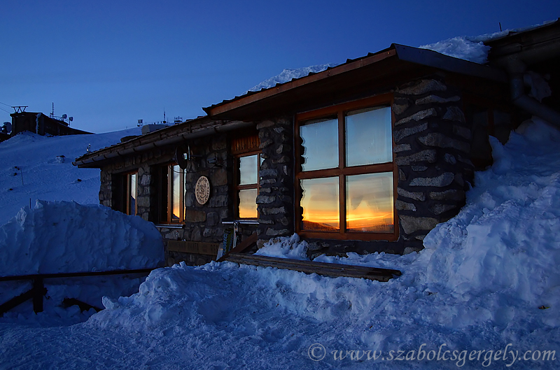 Chopok csúcsánál lévő melegedő ablakában megcsillanó naplemente