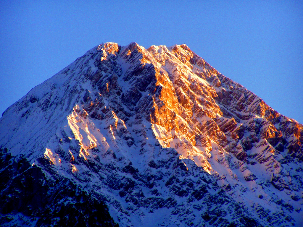 A lemenő Nap utolsó fénysugarai festik narancssárgára a Mittagskogel impozáns szikláit