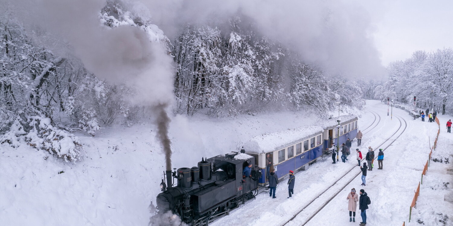 A drónfelvételen Gyermekvasúton közlekedő gőzmozdony vontatta nosztalgiavonat érkezik a behavazott Szépjuhászné megállóba 2023. december 9-én. MTI/Máthé Zoltán